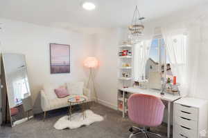 Office space with carpet floors and hanging lights