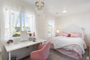 Carpeted bedroom with a chandelier