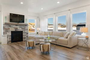 Living area with a fireplace, wood finished floors, and recessed lighting