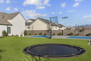 View of sport court with a trampoline and basketball court