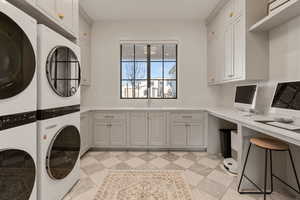 Laundry room with cabinet space, stacked washing machine and dryer, and an office area