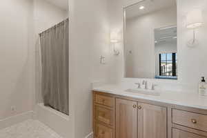 Bathroom with vanity, shower / tub combo with curtain, and recessed lighting