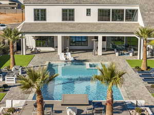 Swimming pool with an outdoor hangout area and a patio