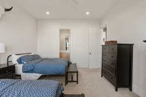 Bedroom with recessed lighting, light colored carpet, connected bathroom, and ceiling fan