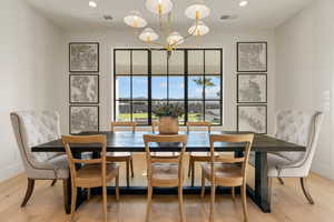 Dining area with hanging lights and light wood-style floors