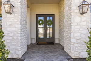 View of exterior entry featuring french doors and stone siding
