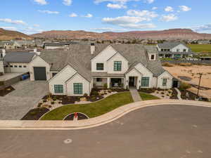 View of front of home with a mountain view, decorative driveway, a porch, and a residential view