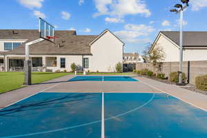 View of sport court with basketball hoop and a patio area