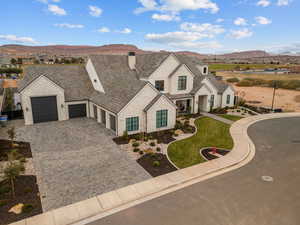View of front of house with a mountain view, decorative driveway, a chimney, an attached garage, and covered porch