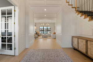 Corridor featuring a decorative wall, light wood-style floors, and recessed lighting