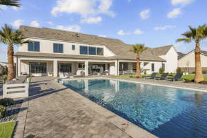 Outdoor pool with a patio area and an outdoor living / dining area