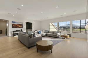 Living room featuring a mountain view, light wood finished floors, and recessed lighting