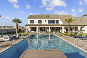Rear view of house featuring a patio, outdoor lounge area, a fenced backyard, stucco siding, and a shingled roof