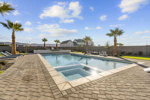 Relaxing pool / spa featuring a fenced backyard, a patio area, and a mountain view