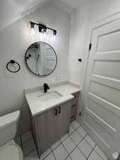 Bathroom with vanity, light tile patterned flooring, and a shower