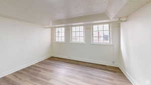 Unfurnished room featuring light wood-style floors and a textured ceiling