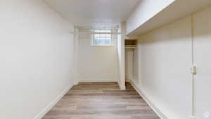 Walk in closet with light wood finished floors
