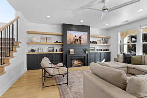 Living room featuring light wood-style floors, recessed lighting, a fireplace, and ceiling fan