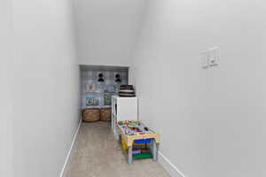 Rec room with carpet and vaulted ceiling