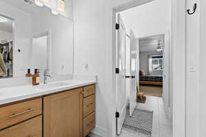 Ensuite bathroom with vanity and light tile patterned floors
