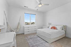 Bedroom featuring light colored carpet and a ceiling fan