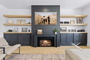 Sitting room with light wood finished floors and a fireplace