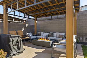Fenced backyard featuring an outdoor living space with a fire pit and a patio area
