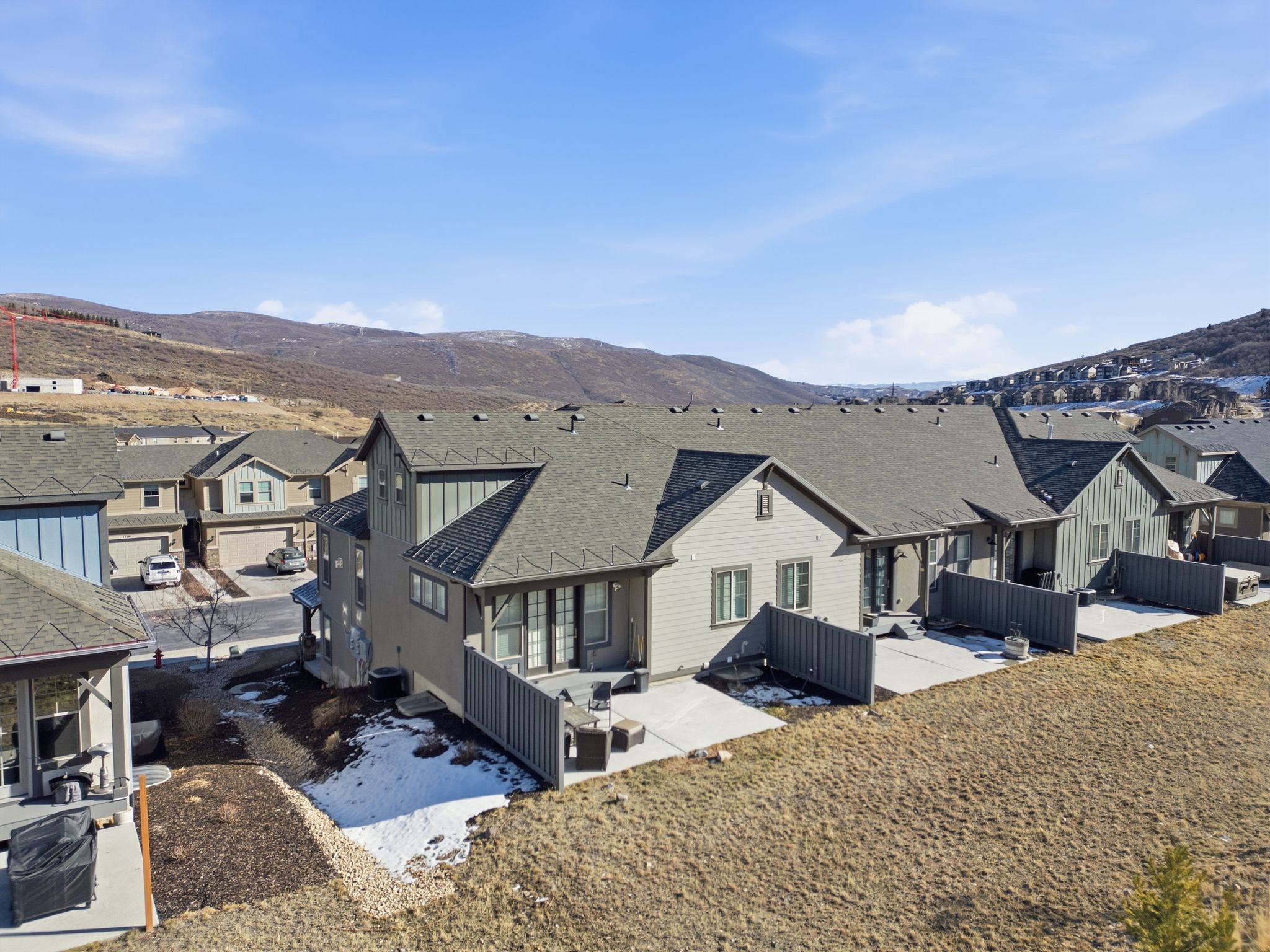 Rear view of house with a patio, a mountain view, a residential view, and a shingled roof