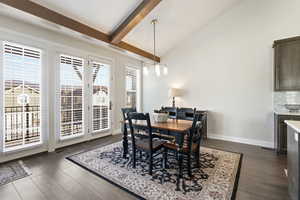 Dining area featuring lofted ceiling and dark wood-style flooring