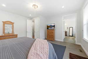 Carpeted bedroom with recessed lighting and connected bathroom