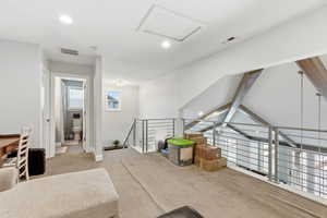 Living area with an upstairs landing, light carpet, recessed lighting, and lofted ceiling with beams