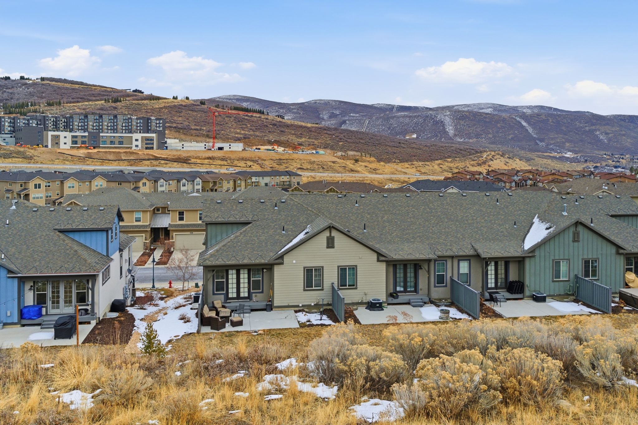 Rear view of property featuring a patio, a mountain view, a shingled roof, and a residential view