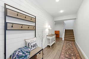 Mudroom featuring wood walls, light wood-style floors, and recessed lighting