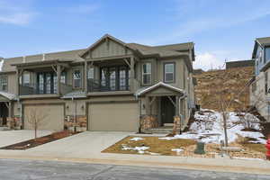 Craftsman-style home featuring a garage, driveway, board and batten siding, and roof with shingles