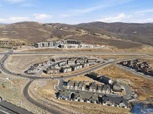 Aerial view of property's location featuring a mountain backdrop and nearby suburban area