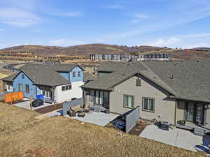 Rear view of property featuring a patio, a shingled roof, a mountain view, and outdoor furniture