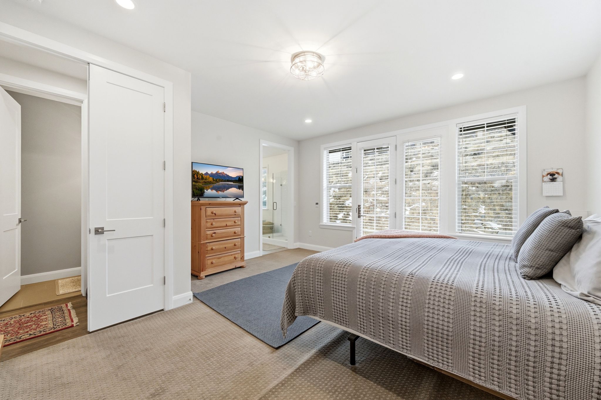 Bedroom with recessed lighting, light colored carpet, and ensuite bath