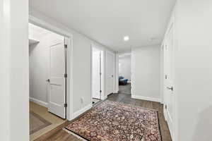 Corridor with dark wood finished floors and recessed lighting