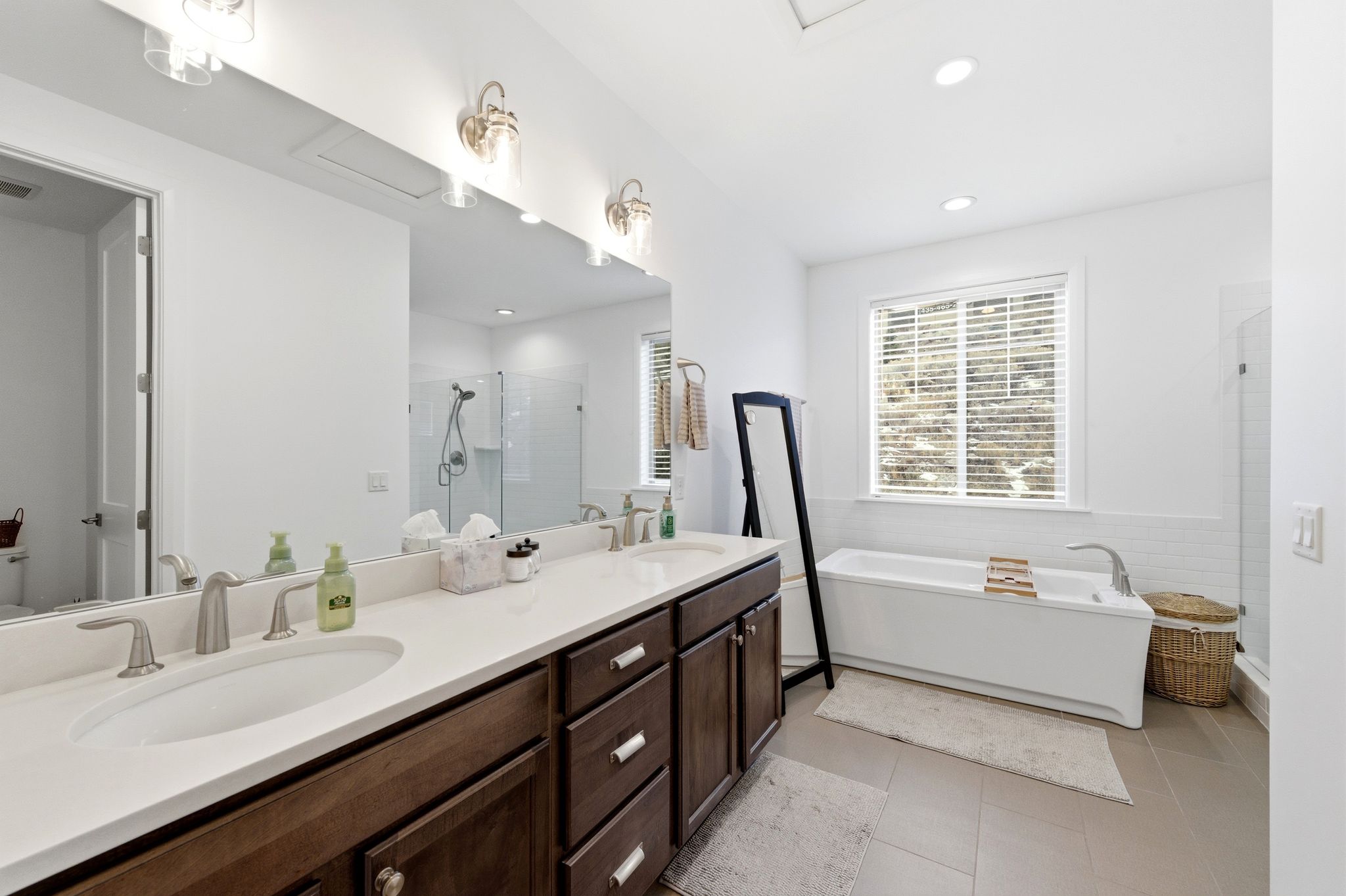 Full bathroom with a shower stall, double vanity, a freestanding bath, recessed lighting, and light tile patterned flooring