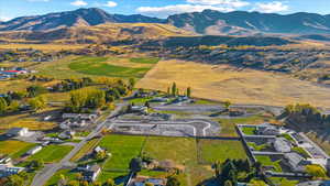 Aerial view of property and surrounding area featuring a mountain backdrop and nearby suburban area