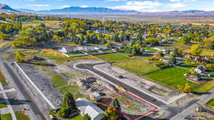 Aerial perspective of suburban area with a mountain backdrop and property parcel outlined