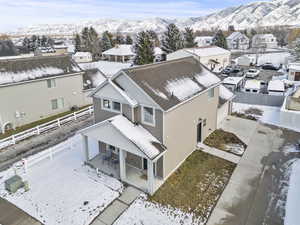 Snowy aerial view featuring a mountain view and a residential view