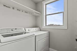 Laundry area featuring washing machine and clothes dryer and lots of shelves (not pictured)