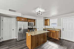 Kitchen with wood finish cabinets, stainless steel appliances, door to garage and a door to side yard