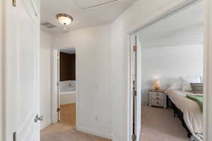 Bedroom with light colored carpet and ensuite bath