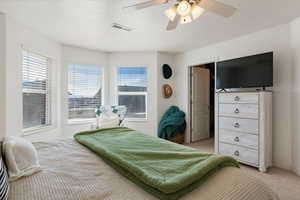 Carpeted bedroom featuring a ceiling fan and baseboards