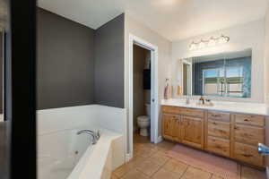 Bathroom with vanity, light tile patterned flooring, and a jetted tub