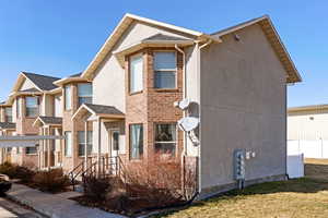 View of front of property with brick siding and stucco siding