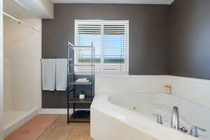 Full bath featuring a stall shower, a whirlpool tub, and light tile patterned flooring