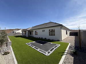 Rear view of house with a fenced backyard, a patio, and a tiled roof